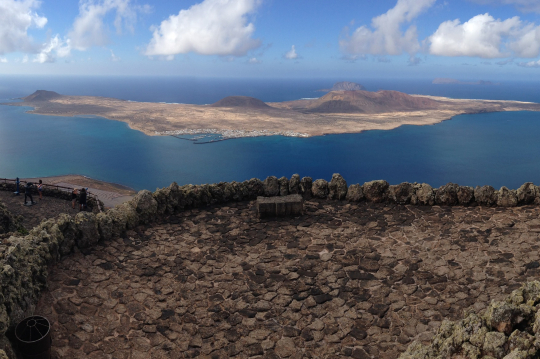Blick von einem Berg &uuml;ber das Meer auf eine kleine vorgelagerte Insel auf Lanzarote